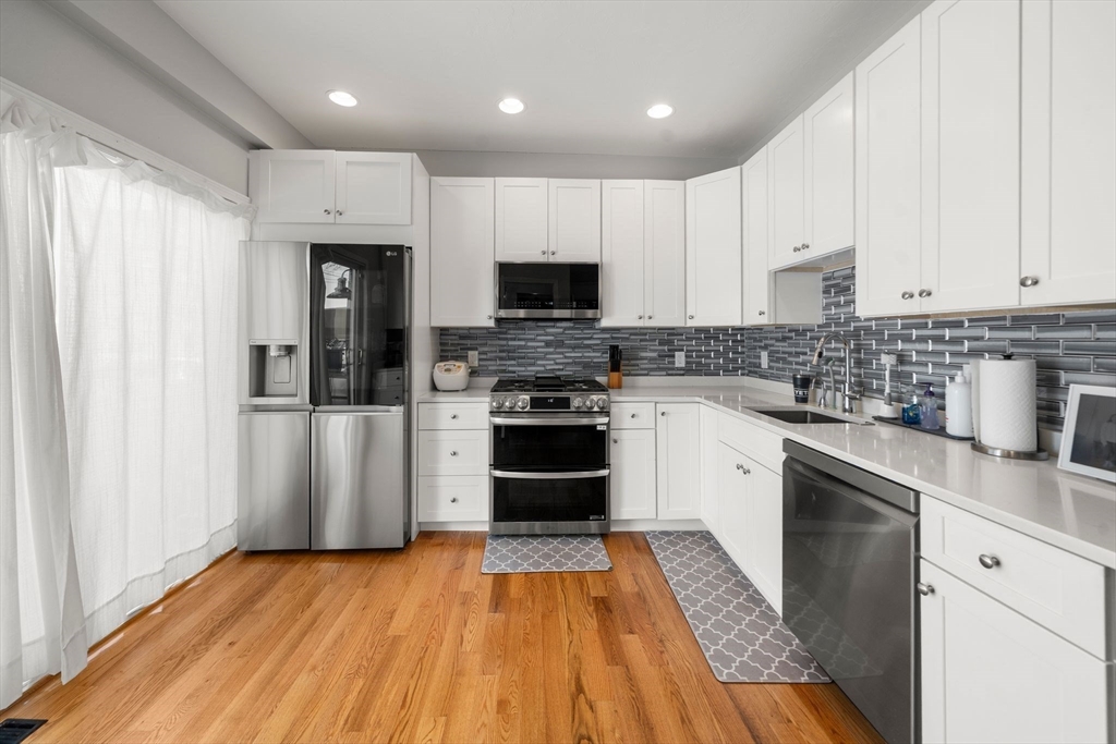 110 D Street Boston, MA 02127 - Photo 3 of 33 a kitchen with granite countertop stainless steel appliances and wooden cabinets
