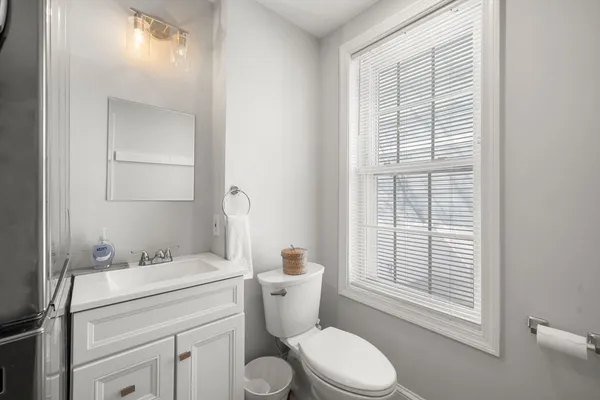 a bathroom with a granite countertop toilet a sink and a mirror