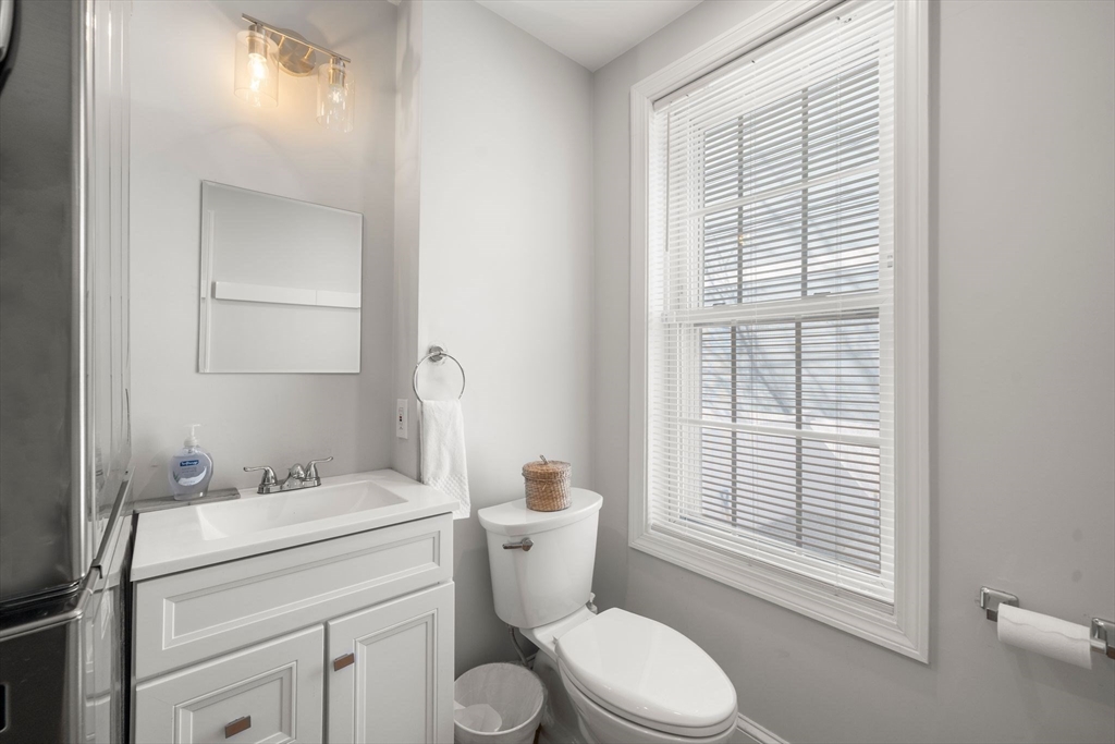 110 D Street Boston, MA 02127 - Photo 6 of 33 a bathroom with a granite countertop toilet a sink and a mirror