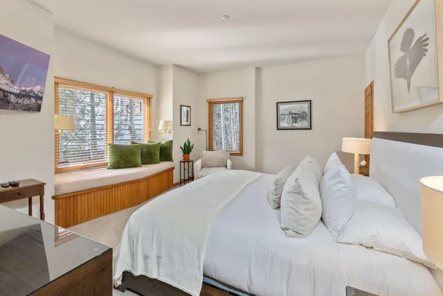 a spacious bedroom with two bed and a large window