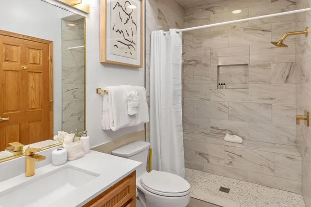 a bathroom with a sink a toilet and shower