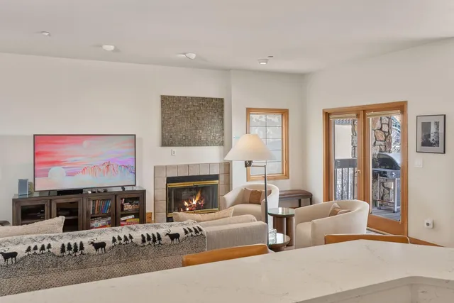 a living room with furniture large window and fireplace
