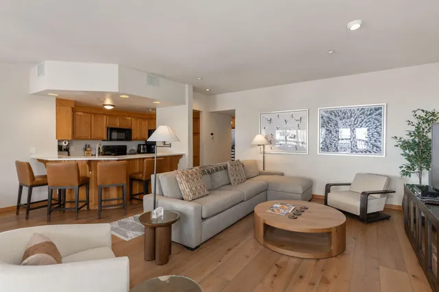 a living room with furniture and a view of kitchen