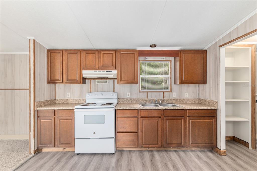 8535 Southwest 155th Street Dunnellon, FL 34432 - Photo 13 of 35 a kitchen with a stove a sink and wooden floor