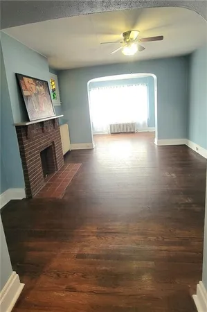 a view of a livingroom with wooden floor and a fireplace