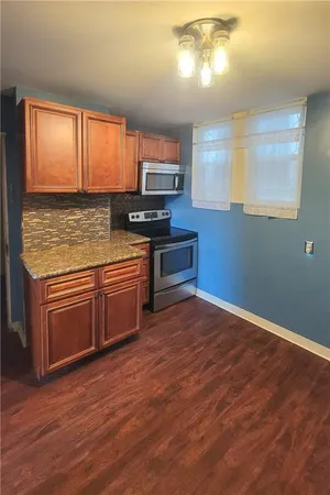 a kitchen with stainless steel appliances granite countertop a stove a sink and a microwave