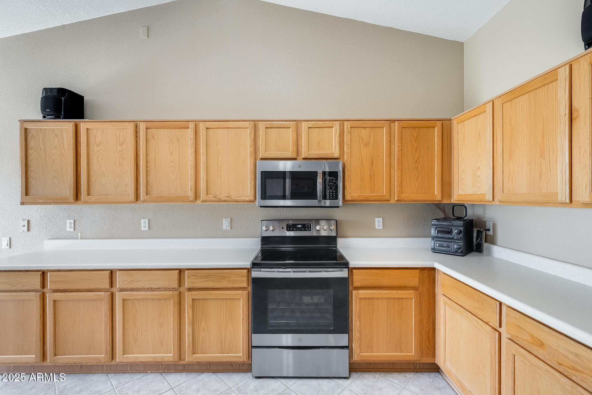 642 South Thunderbird Drive Apache Junction, AZ 85120 - Photo 14 of 53 a kitchen with granite countertop a stove a sink and a microwave