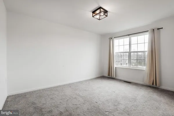 an empty room and a bathroom with a toilet
