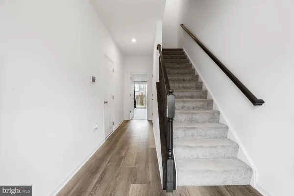 a view of entryway and gallery with wooden floor