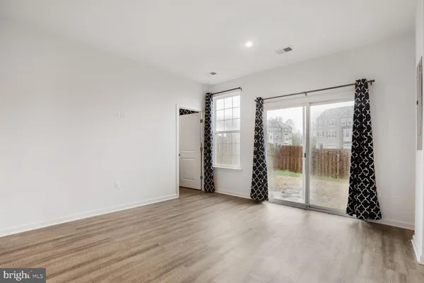 an empty room with sliding door and wooden floor
