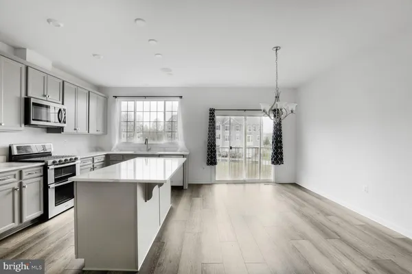 a large kitchen with stainless steel appliances a large counter top a stove a chimney a sink and a window