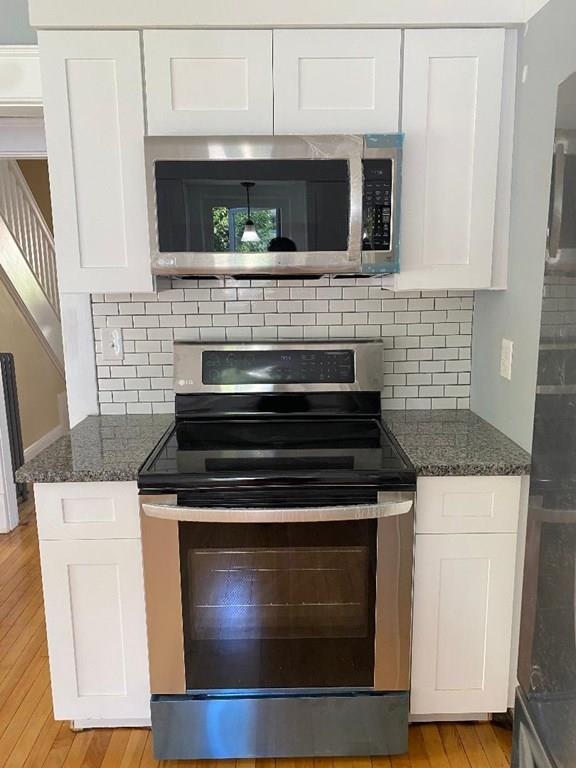 64 Chilson Street Springfield, MA 01118 - Photo 12 of 36 a stove top oven sitting inside of a kitchen and wooden cabinets