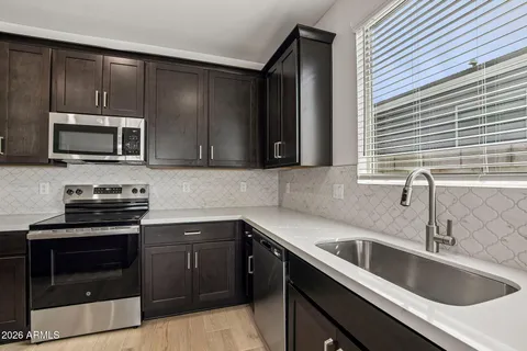 a kitchen with a sink and steel appliances