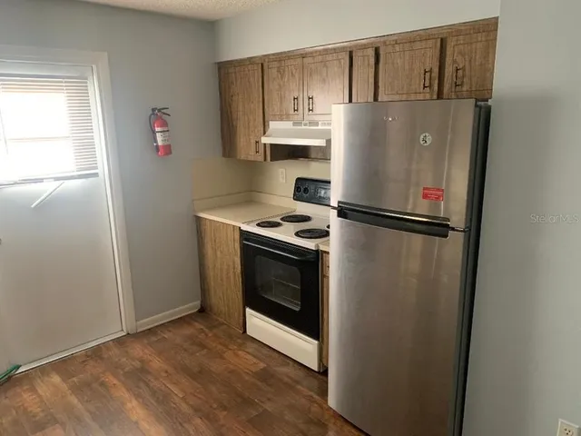 a white refrigerator freezer and a stove sitting inside of a kitchen