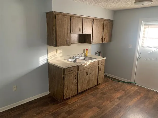 a kitchen with a sink cabinets and wooden floor