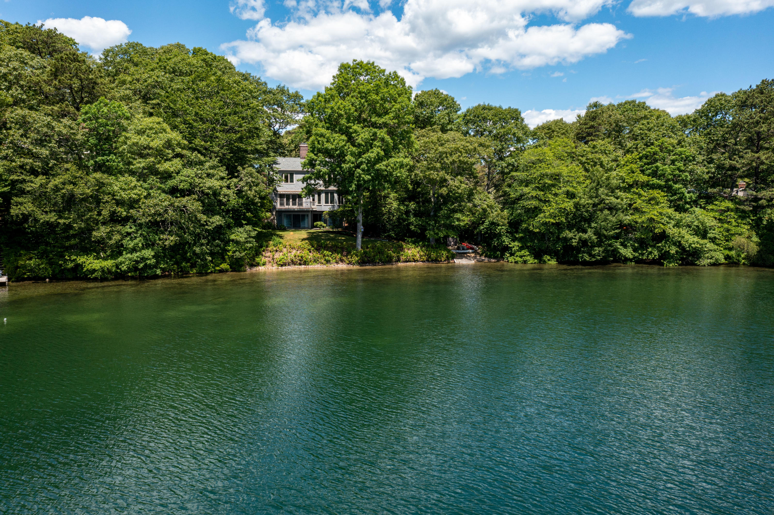 316 Wheeler Road Marstons Mills, MA 02648 - Photo 45 of 50 a view of a lake with houses in the background