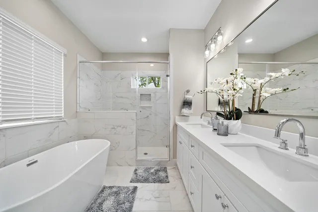a bathroom with a tub sink shower and mirror
