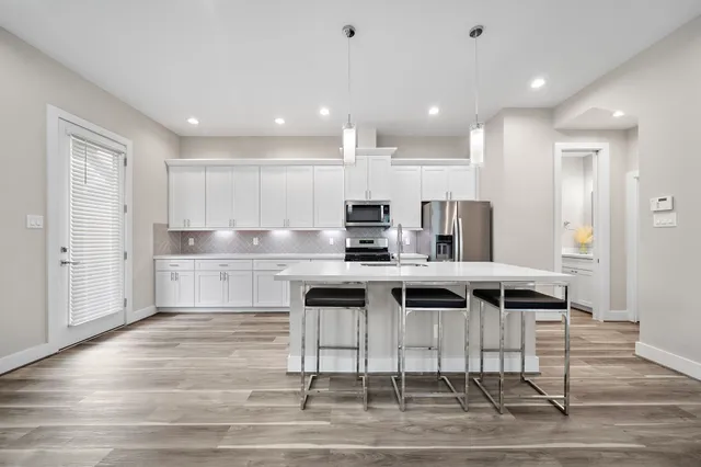 a kitchen with kitchen island stainless steel appliances a sink and cabinets