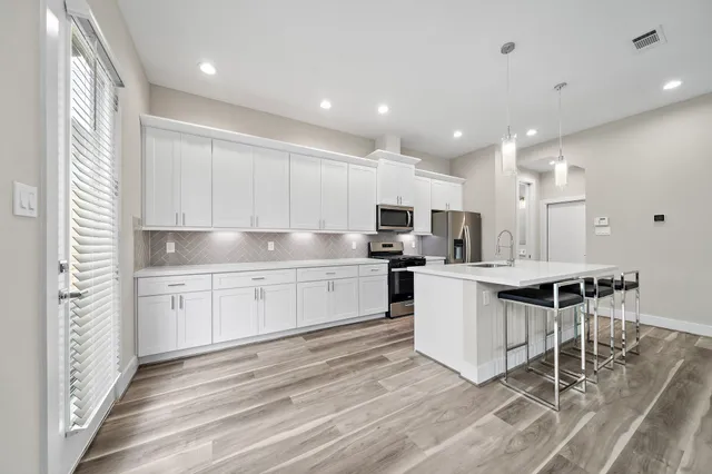 a kitchen with white cabinets and appliances