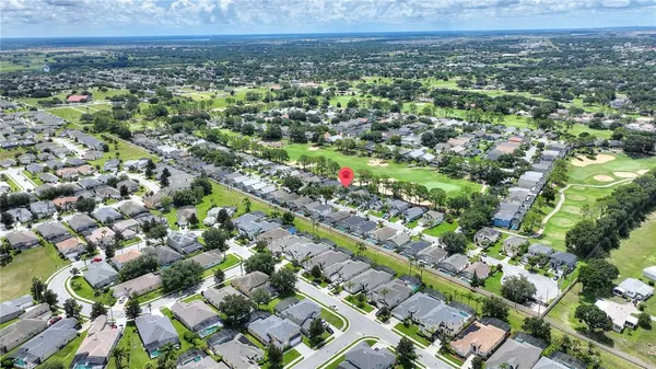 an aerial view of residential houses with outdoor space and trees