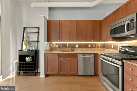 a kitchen with stainless steel appliances granite countertop a stove a sink and a microwave