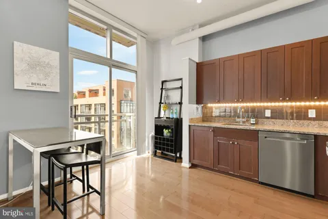 a kitchen with granite countertop wooden cabinets and dining table