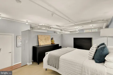 a bedroom with a large bed and a tv on the dresser