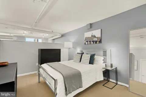 a bedroom with a large bed and a chandelier