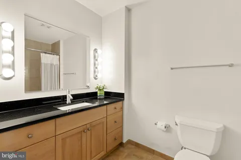 a bathroom with a granite countertop sink and a mirror