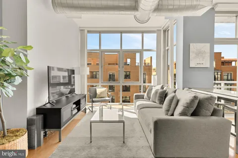 a living room with furniture and a floor to ceiling window