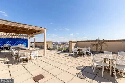 a view of a patio with dining table and chairs with a barbeque grill and couches