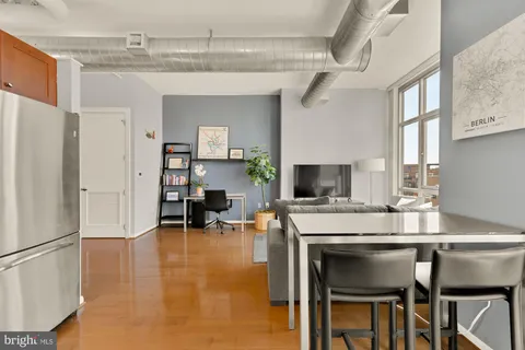 a kitchen with a table chairs refrigerator and cabinets