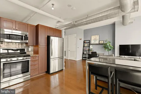 a kitchen with a refrigerator and a stove top oven
