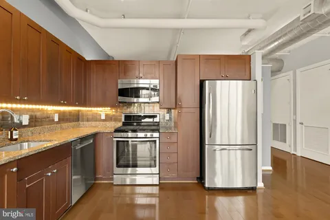 a kitchen with a refrigerator sink and wooden cabinets
