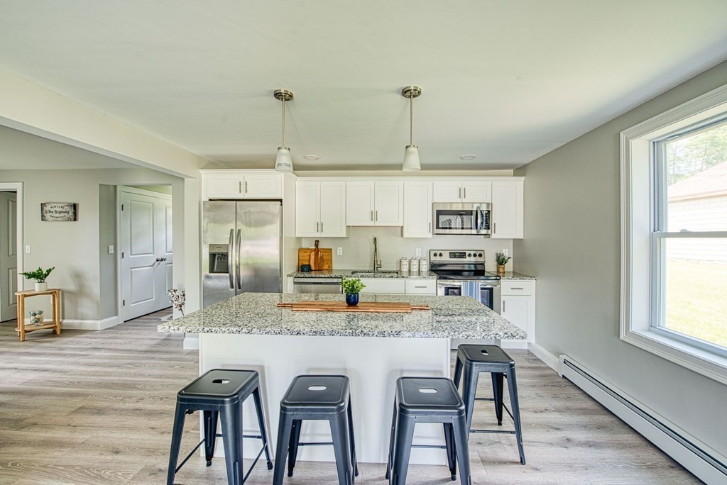 43 County Road East Freetown, MA 02717 - Photo 1 of 27 a open kitchen with granite countertop a stove a sink a dining table and chairs with wooden floor