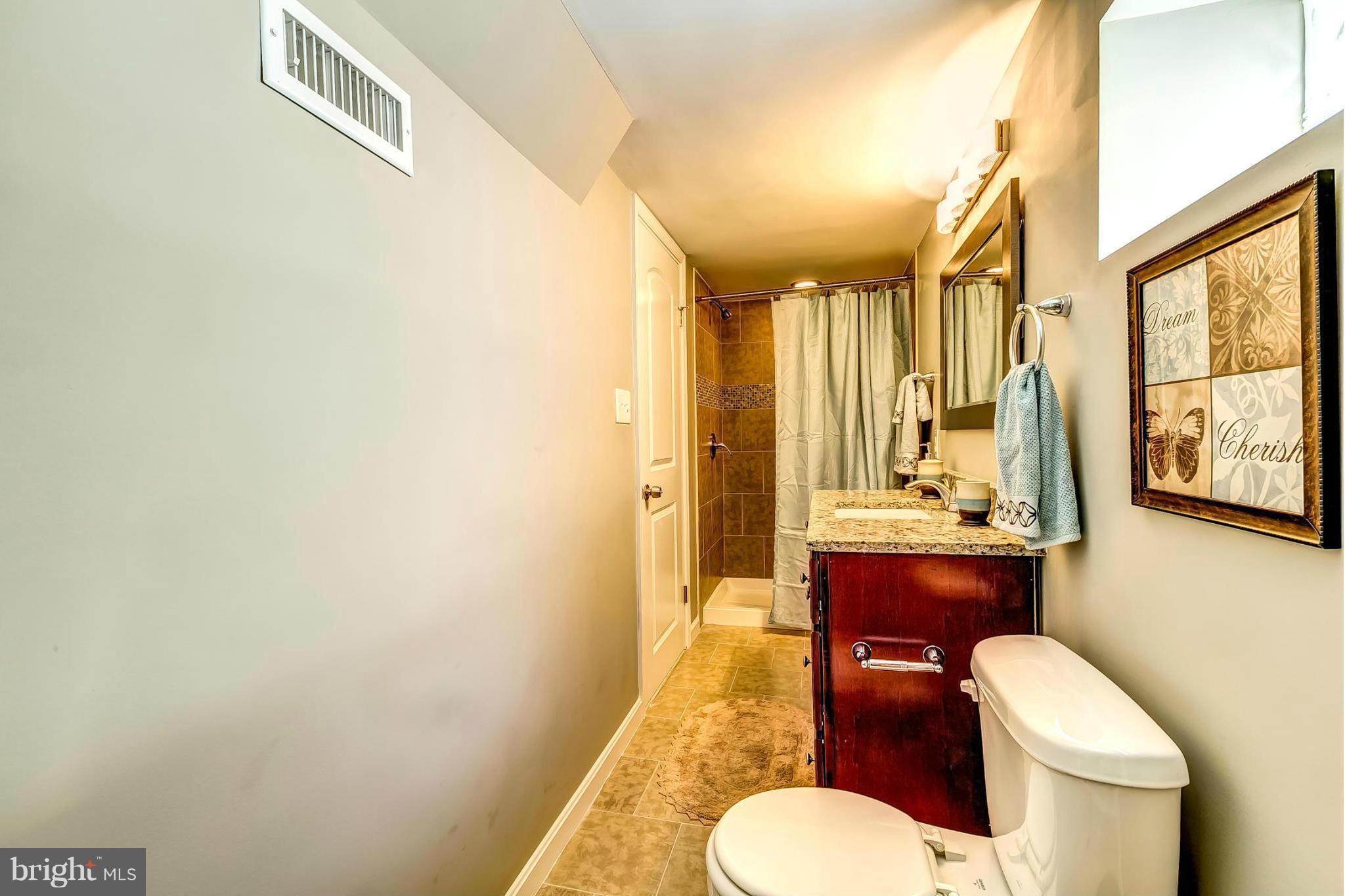 8304 Oakleigh Road Baltimore, MD 21234 - Photo 26 of 30 a bathroom with a toilet a sink and mirror