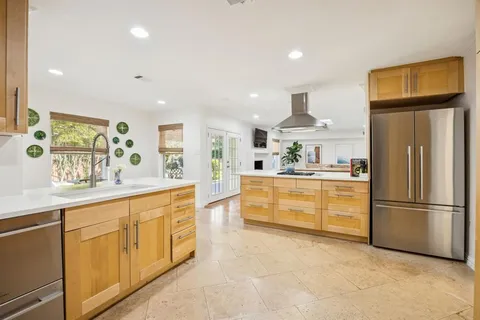 a kitchen with granite countertop a refrigerator and a sink