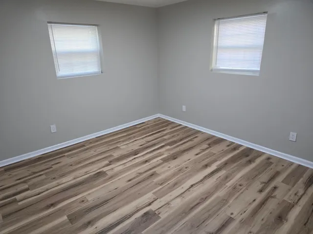 a view of a room with wooden floor and windows