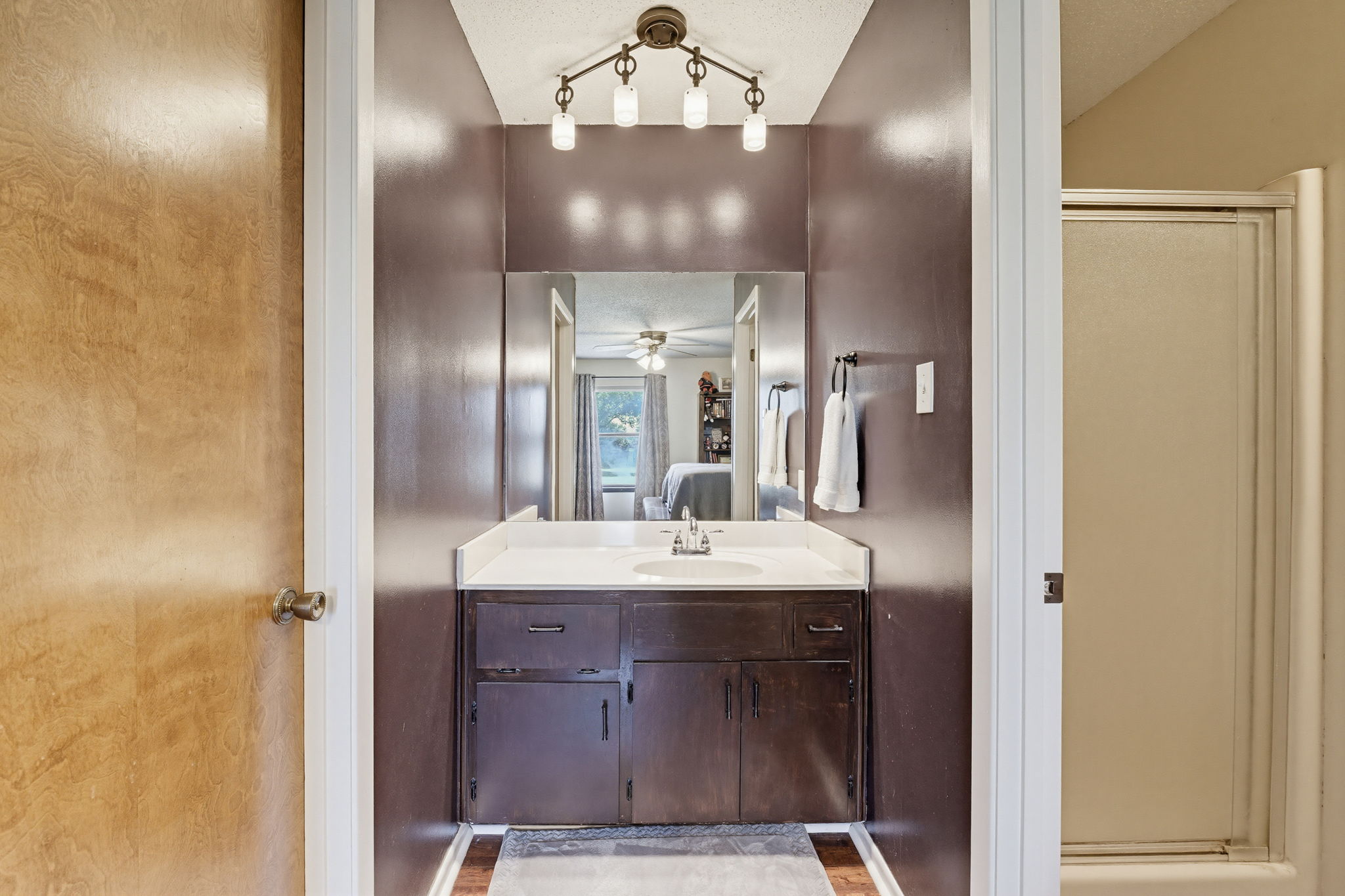 120 Rae Lane Jarrell, TX 76537 - Photo 33 of 40 Bathroom vanity with dark wood-finish cabinetry, a white countertop, and an integrated sink
