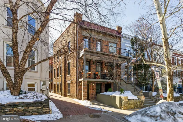 a front view of a building with large trees