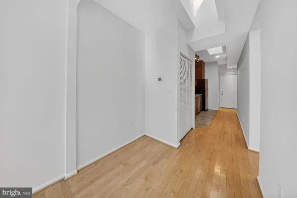 a view of a room with wooden floor and a hallway