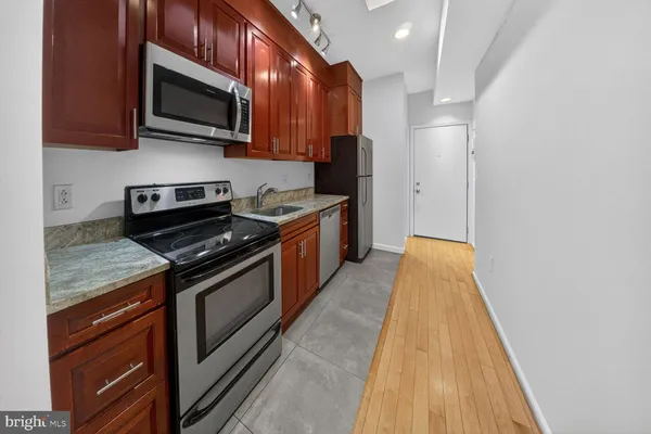 a kitchen with stainless steel appliances granite countertop a stove and a microwave
