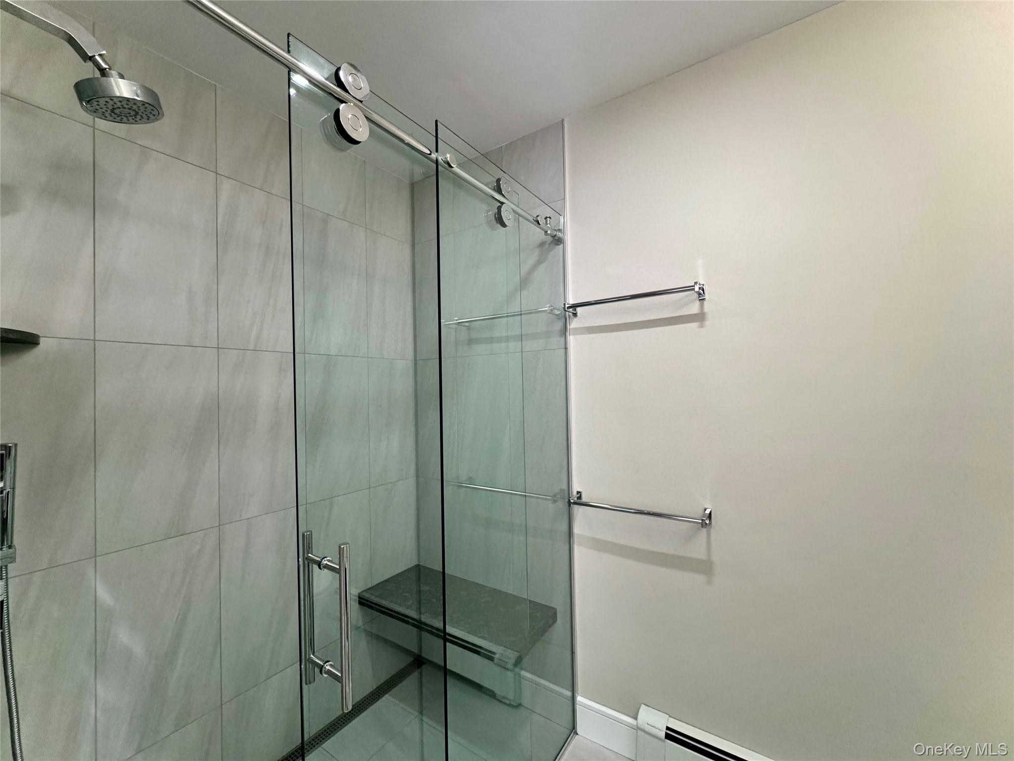 1 Deer Path Quogue, NY 11959 - Photo 20 of 38 Full bathroom featuring a stall shower, a baseboard radiator, and tile patterned floors