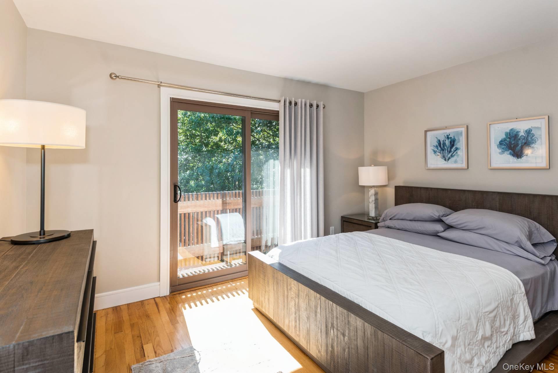 1 Deer Path Quogue, NY 11959 - Photo 24 of 38 a bedroom with a large bed and a lamp