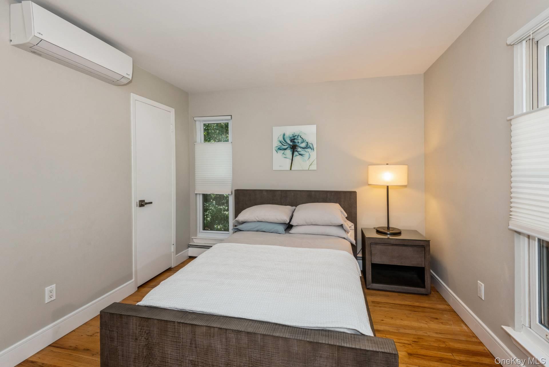 1 Deer Path Quogue, NY 11959 - Photo 27 of 38 a bedroom with a bed and a lamp on the dresser