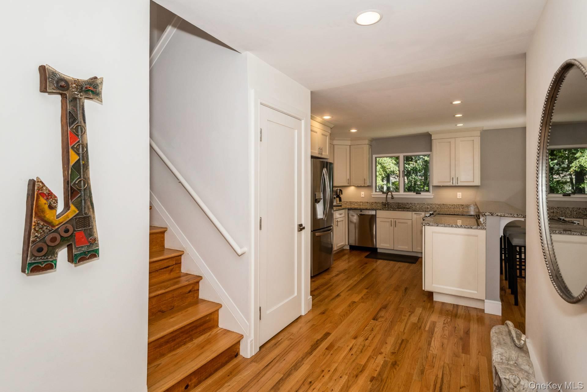 1 Deer Path Quogue, NY 11959 - Photo 6 of 38 Kitchen with recessed lighting, dark wood-type flooring, light stone countertops, a peninsula, and appliances with stainless steel finishes