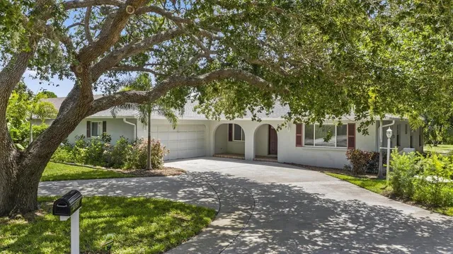 a front view of a house with a yard and a garden