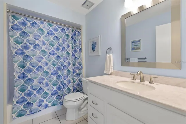 a bathroom with a granite countertop sink a toilet and a mirror