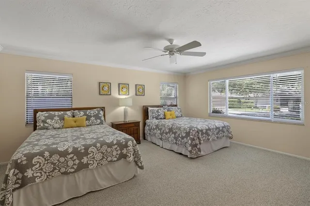 a bedroom with two beds and a large window