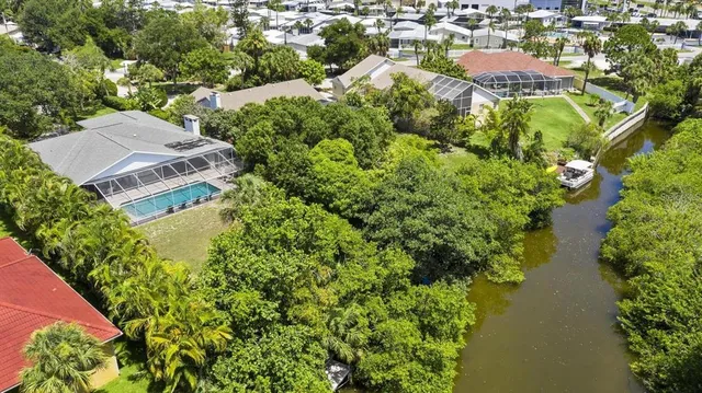 an aerial view of residential house with outdoor space and trees all around